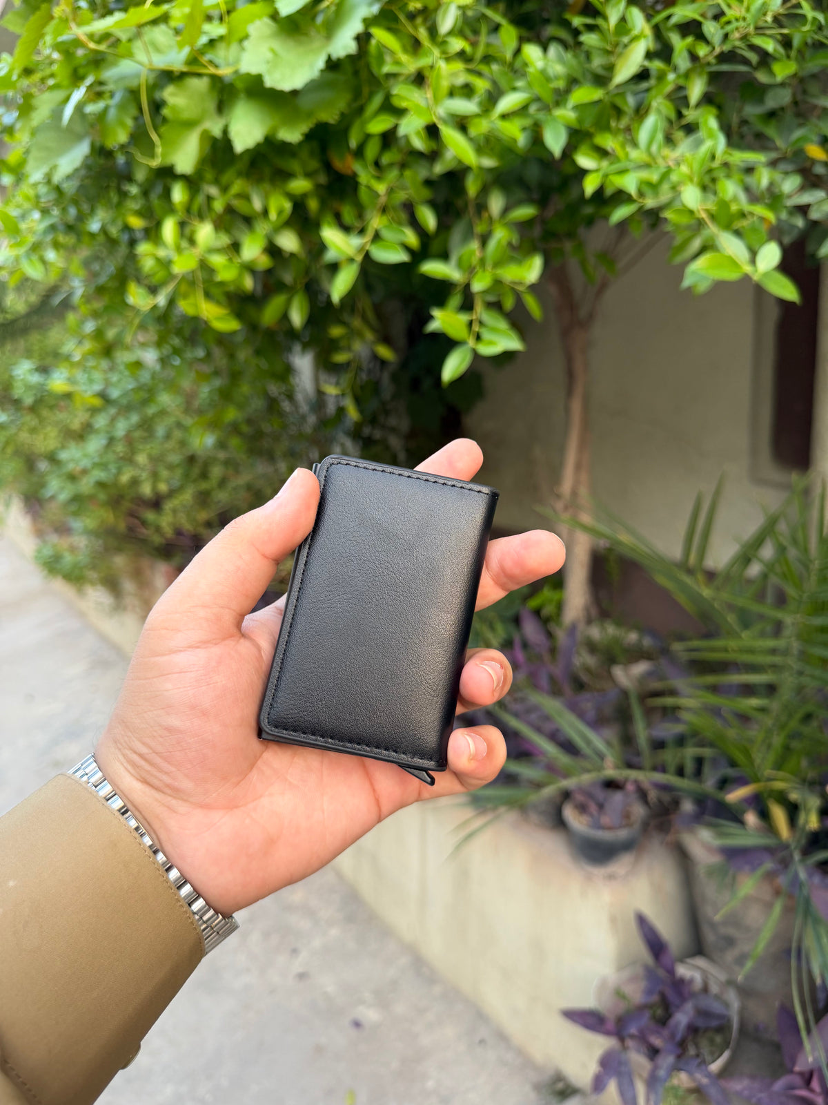 Black Pop-Up Bifold Wallet closed front view showing leather-wrapped aluminium shell