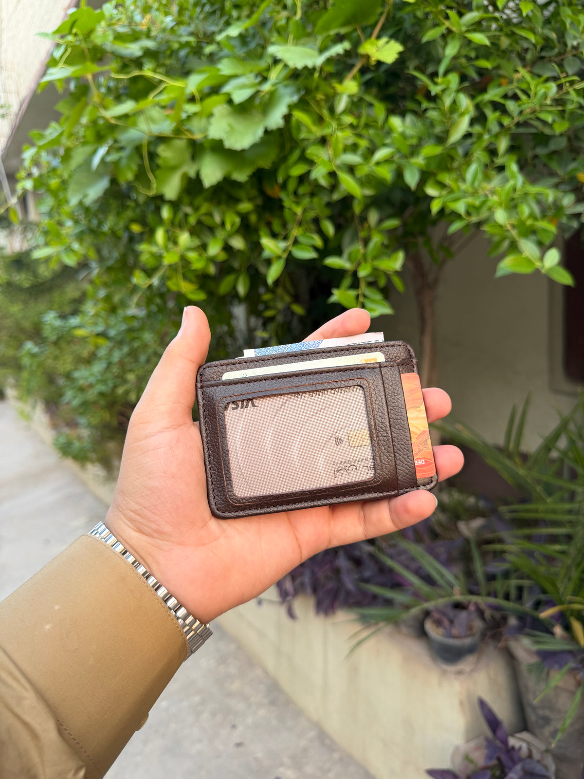 Dark Brown Slim Card Holder outdoor front view showing pebbled leather texture and side card slots