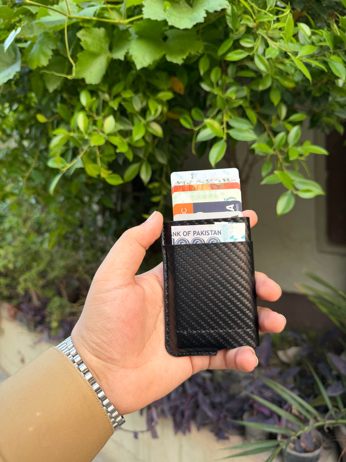Black Carbon Fibre Wallet with aluminium card ejector popped up showing Visa card