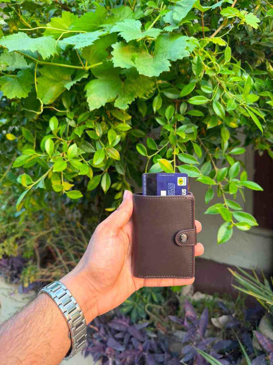 Dark Brown Pop-Up Wallet outdoor view with cards ejected from aluminium mechanism