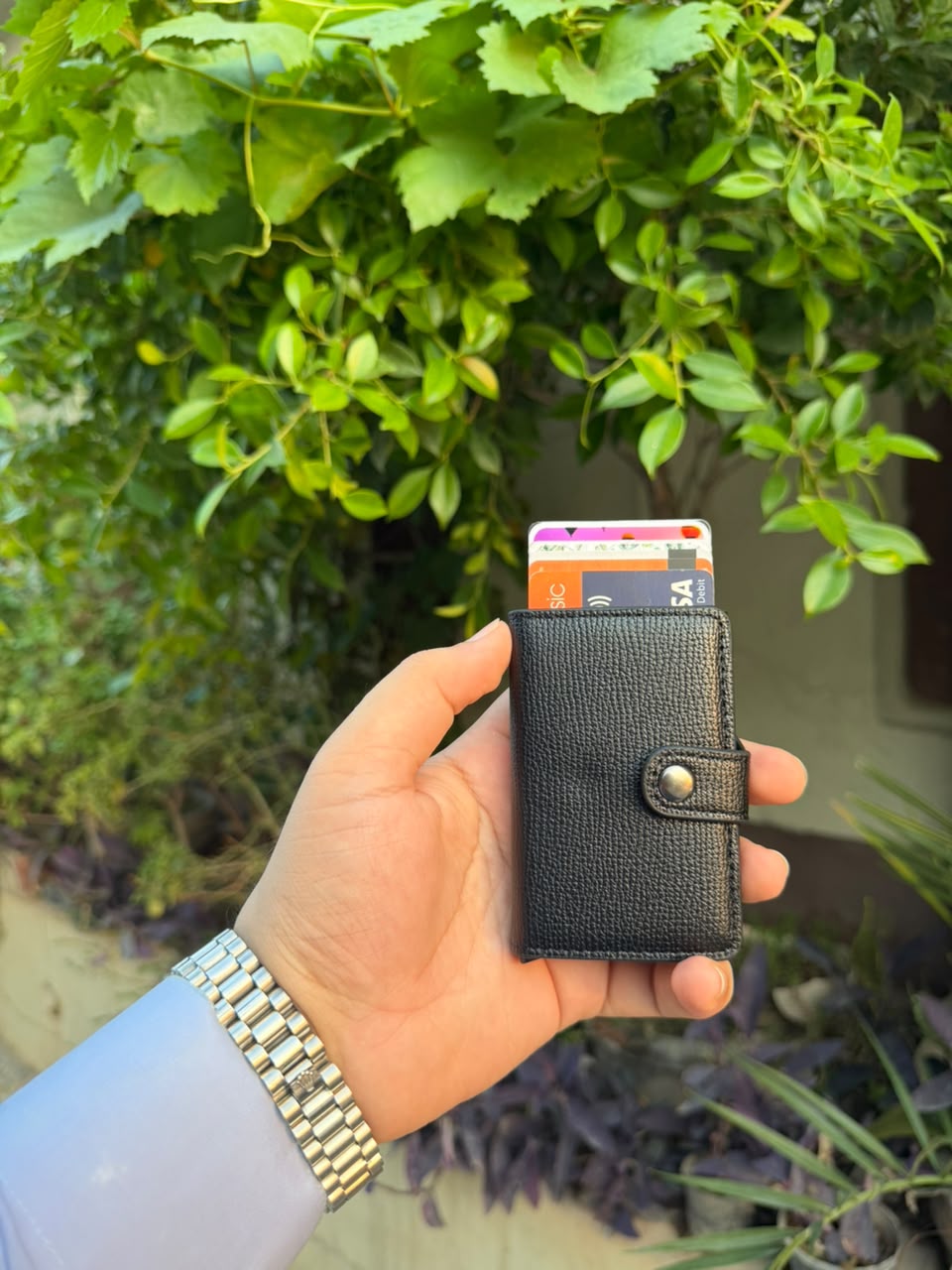 Black Pop-Up Card Wallet with cards ejected showing Visa and debit cards